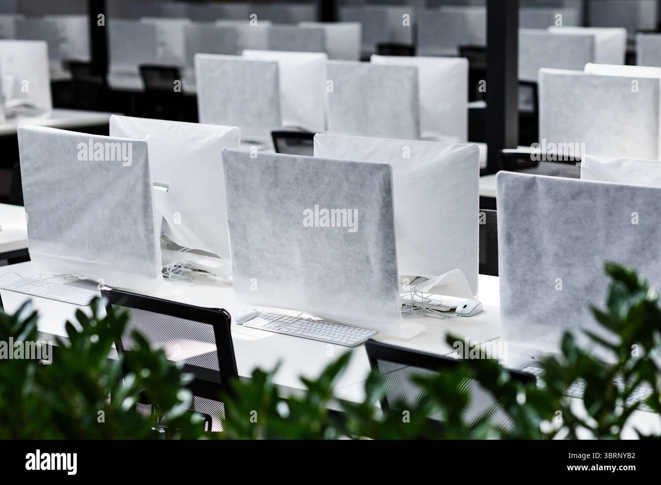 Big office with covered computers with no workers Stock Photo