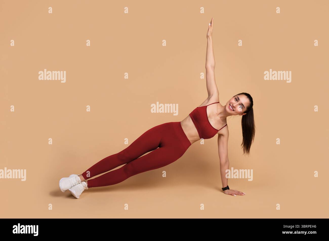 Smiling Young Woman Doing Side Plank Balance Exercise Stock Photo