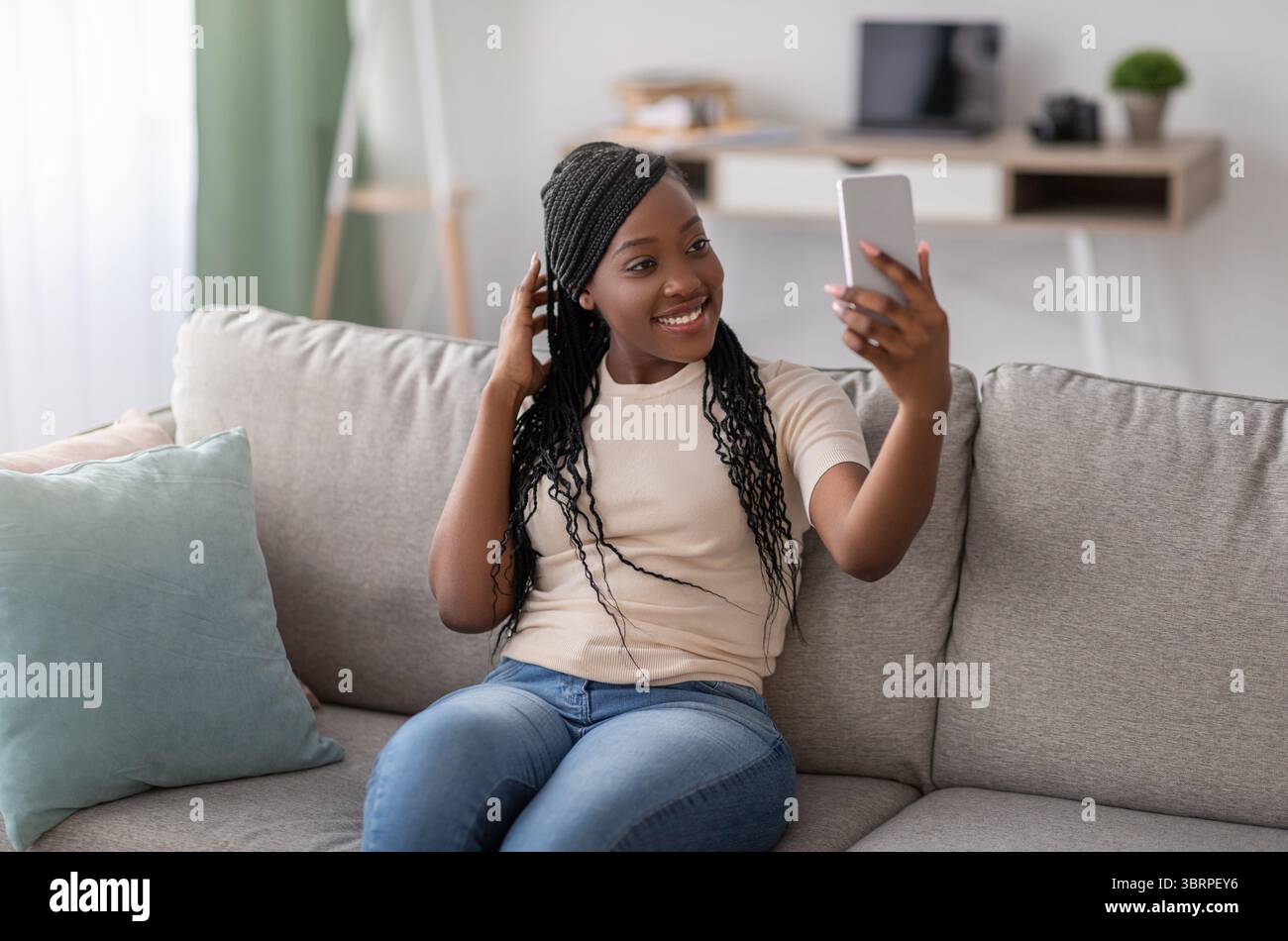 Cute young black lady taking selfie on smartphone Stock Photo