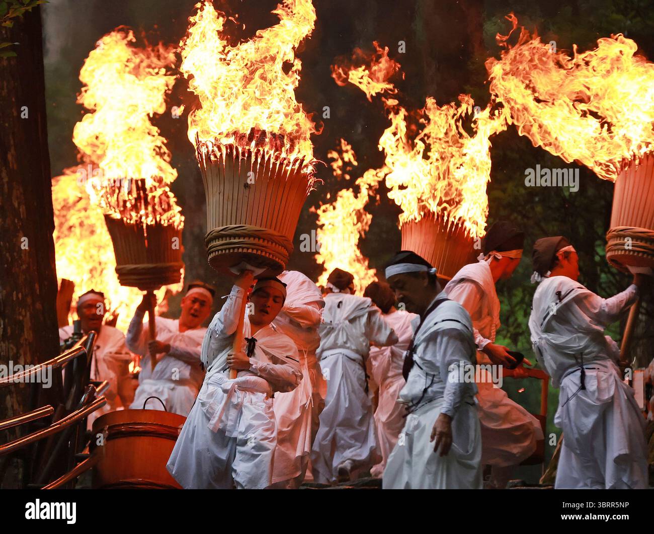 Shinto-Shrine parishioners wearing white robes descend the stairs while ...
