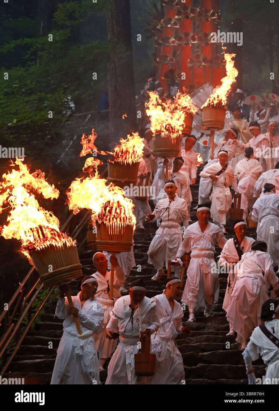 Shinto-Shrine parishioners wearing white robes ascend and descend the ...