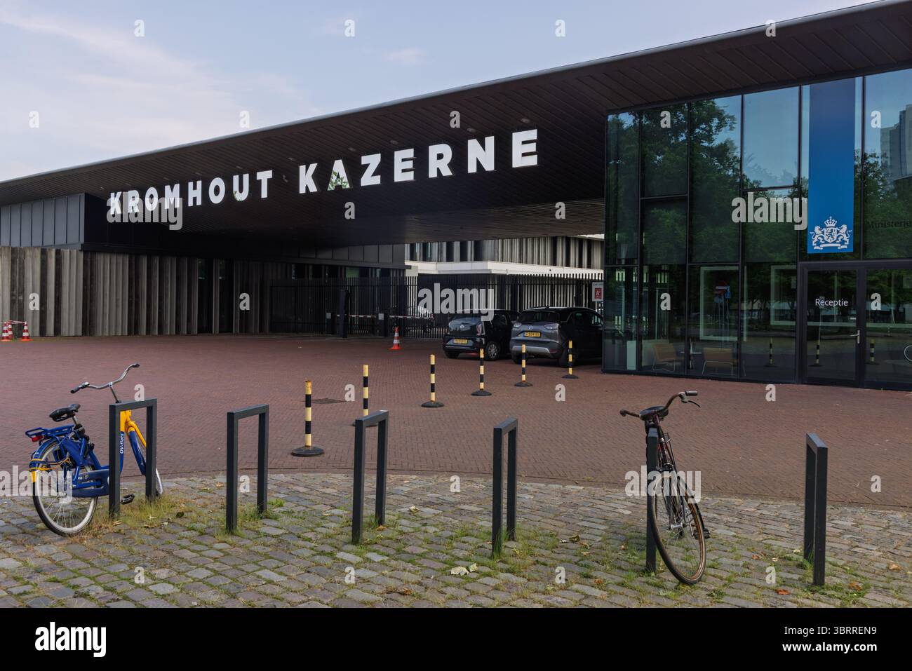 Modern entrance of Kromhout Kazerne in Utrecht, Netherlands, with bicycles and cars in front of the Dutch Ministry of Defence building. Utrecht, Nethe Stock Photo