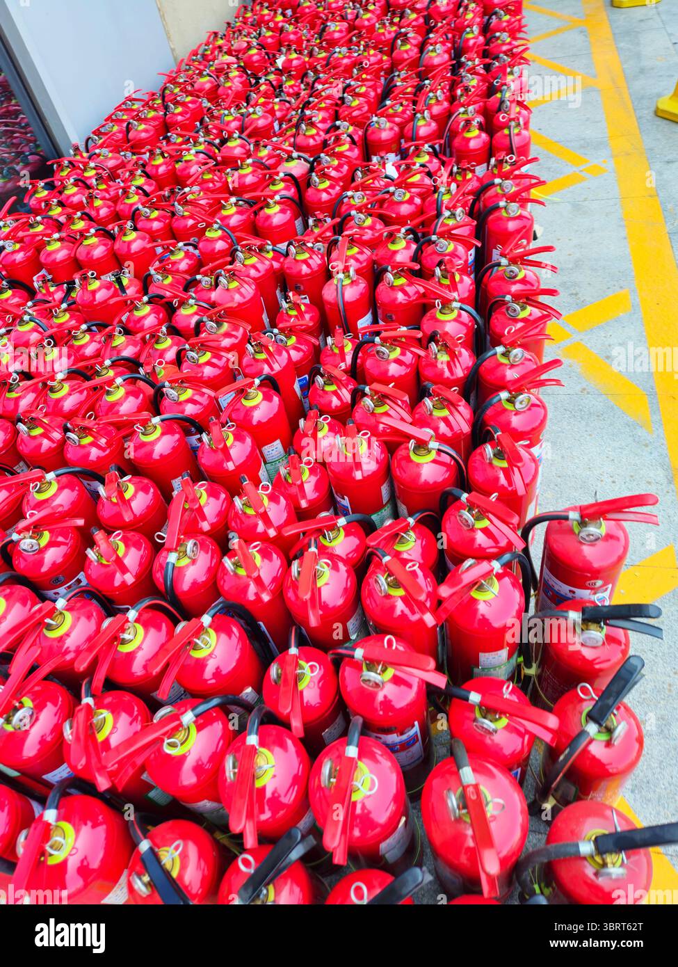 Rows of Red Fire Extinguishers in Warehouse Safety Zone – Industrial Emergency Equipment Storage Stock Photo