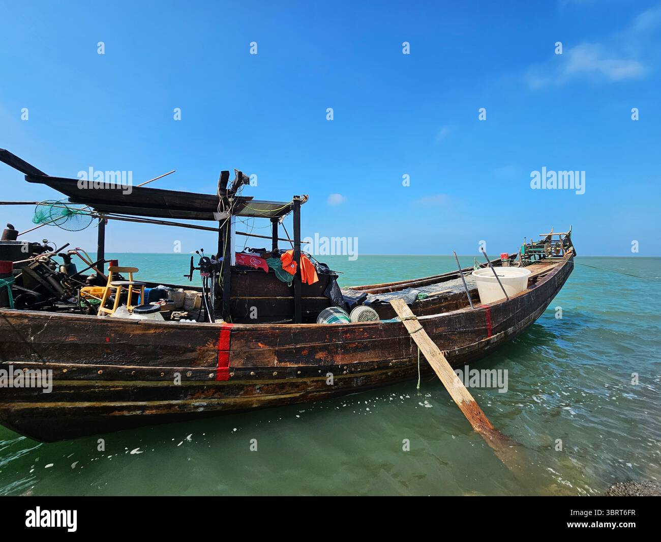 Traditional Wooden Fishing Boat on Green Sea under Clear Blue Sky Stock ...