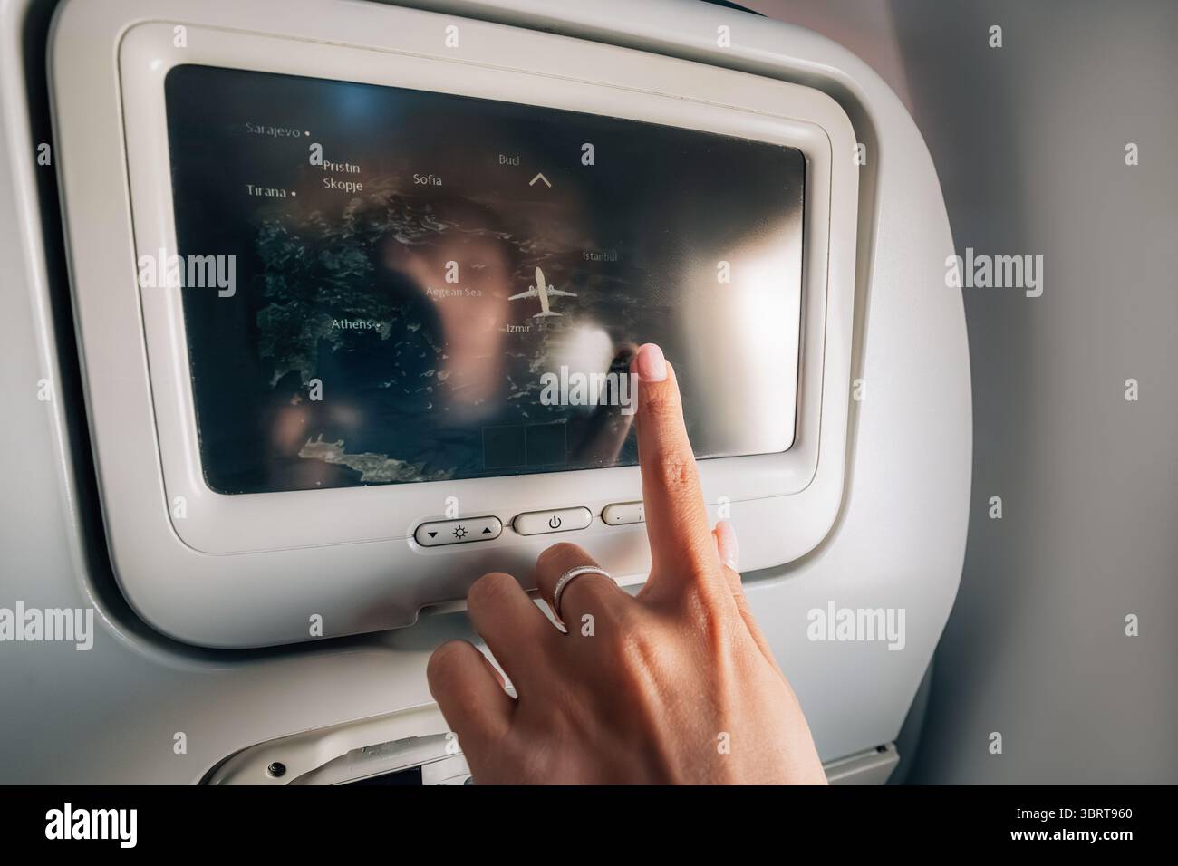 Hand using touchscreen on airplane to check flight route over map Stock ...