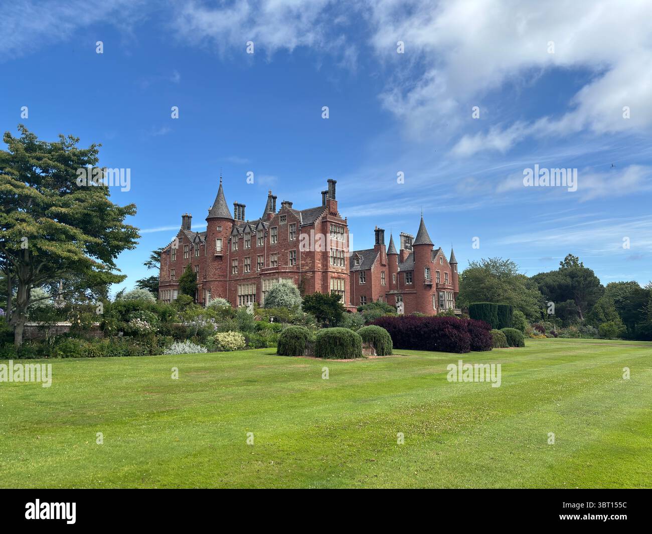 Tyninghame House, a red-sandstone Scots baronial mansion near the River Tyne estuary, set in expansive gardens—built in 1829 over earlier medieval Stock Photo
