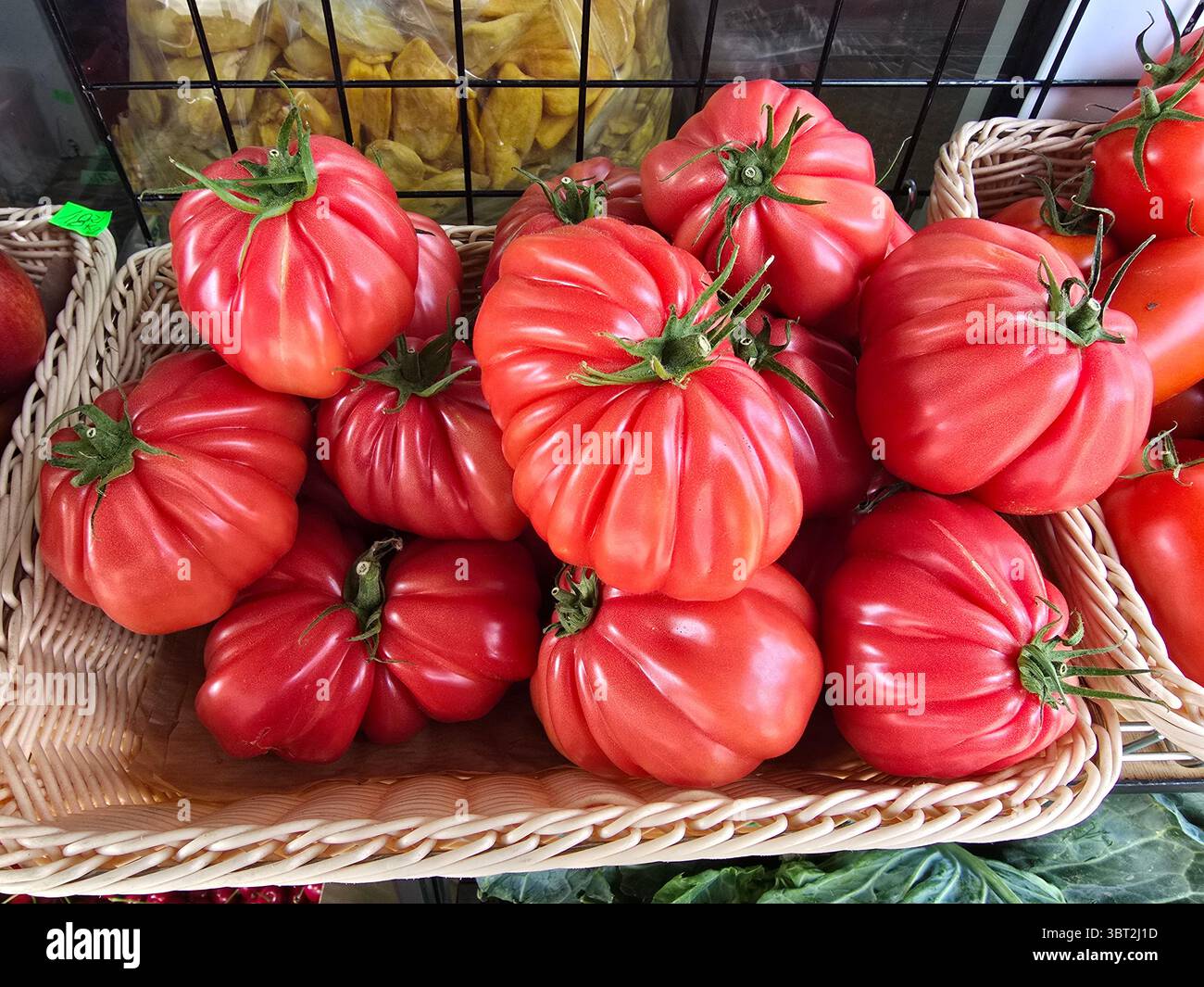 Beef Tomatoes displayed by a vendor at the colorful farmers market on Niekłańska street in Warsaw, Poland. - Smartphone Captured Stock Image