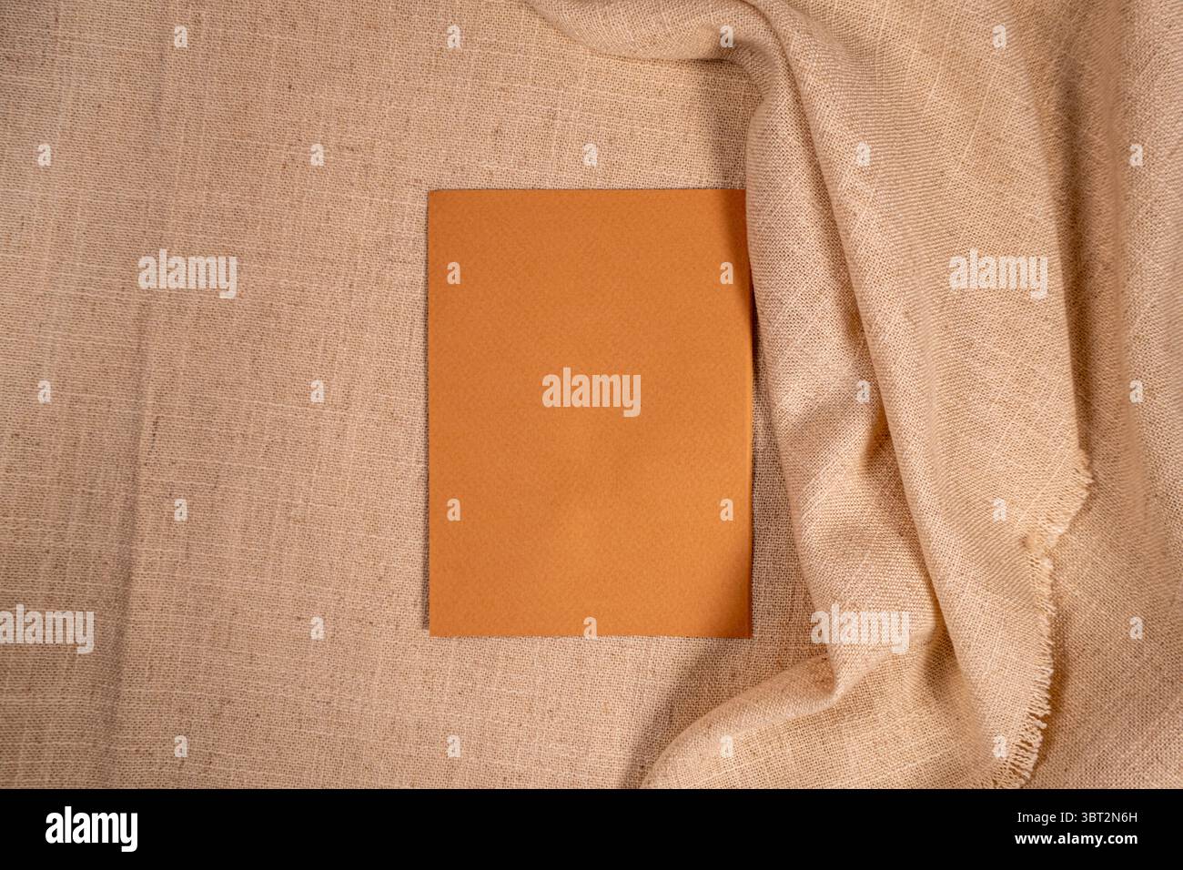 Minimal brown card on beige linen fabric aesthetic flat lay background with copy space Stock Photo