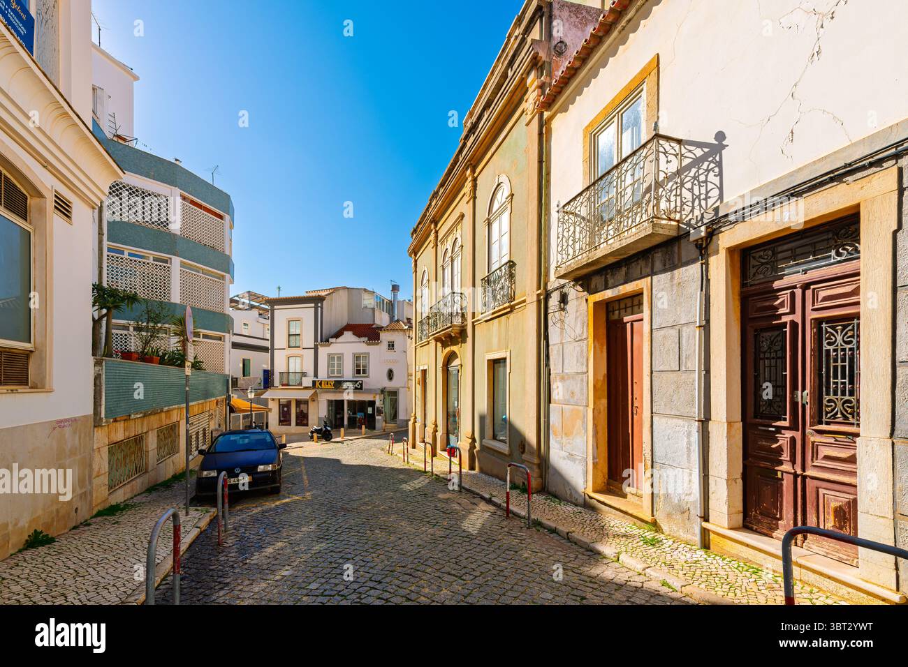 A picturesque tiled street of shops and sidewalk cafes in the historic old town of seaside Lagos, Portugal, in the Algarve region of Southern Portugal Stock Photo