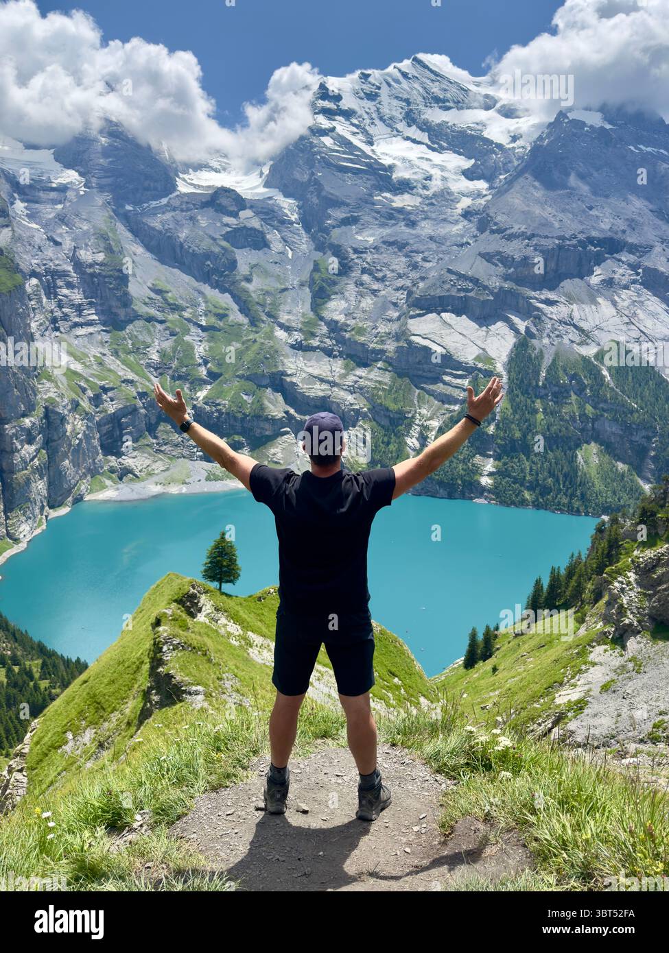 Hiker enjoys the panorama view over Lake Oeschinensee - Smartphone Captured Stock Image