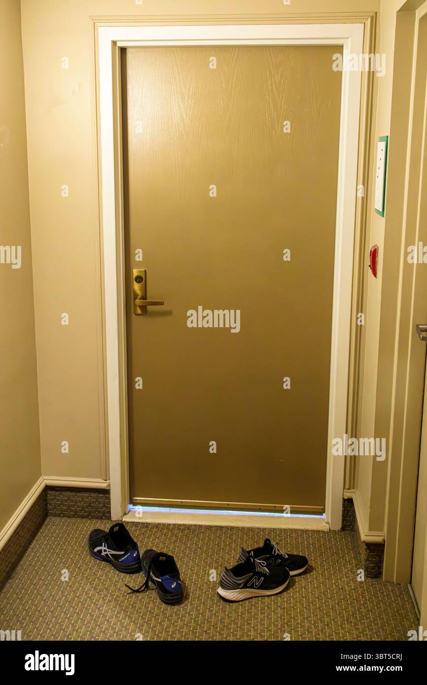 Miami Beach Florida,North Beach,condominium building hall hallway,door entrance apartment unit,indoor carpeted floor,beige wall neutral colors,shoes l Stock Photo