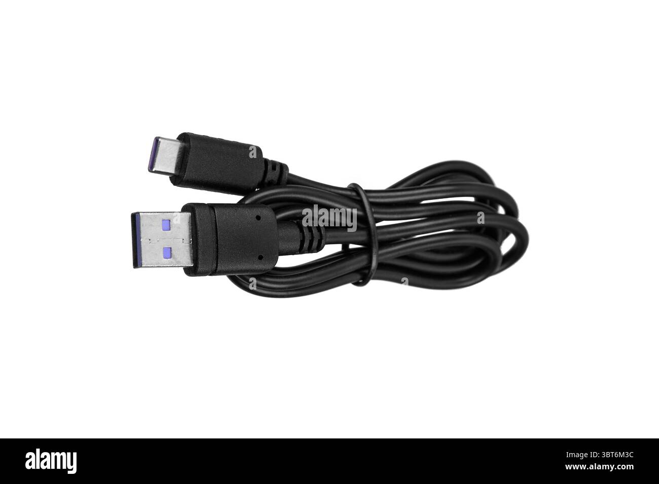 Black USB-A to USB-C charging cable coiled and ready for use. Stock Photo