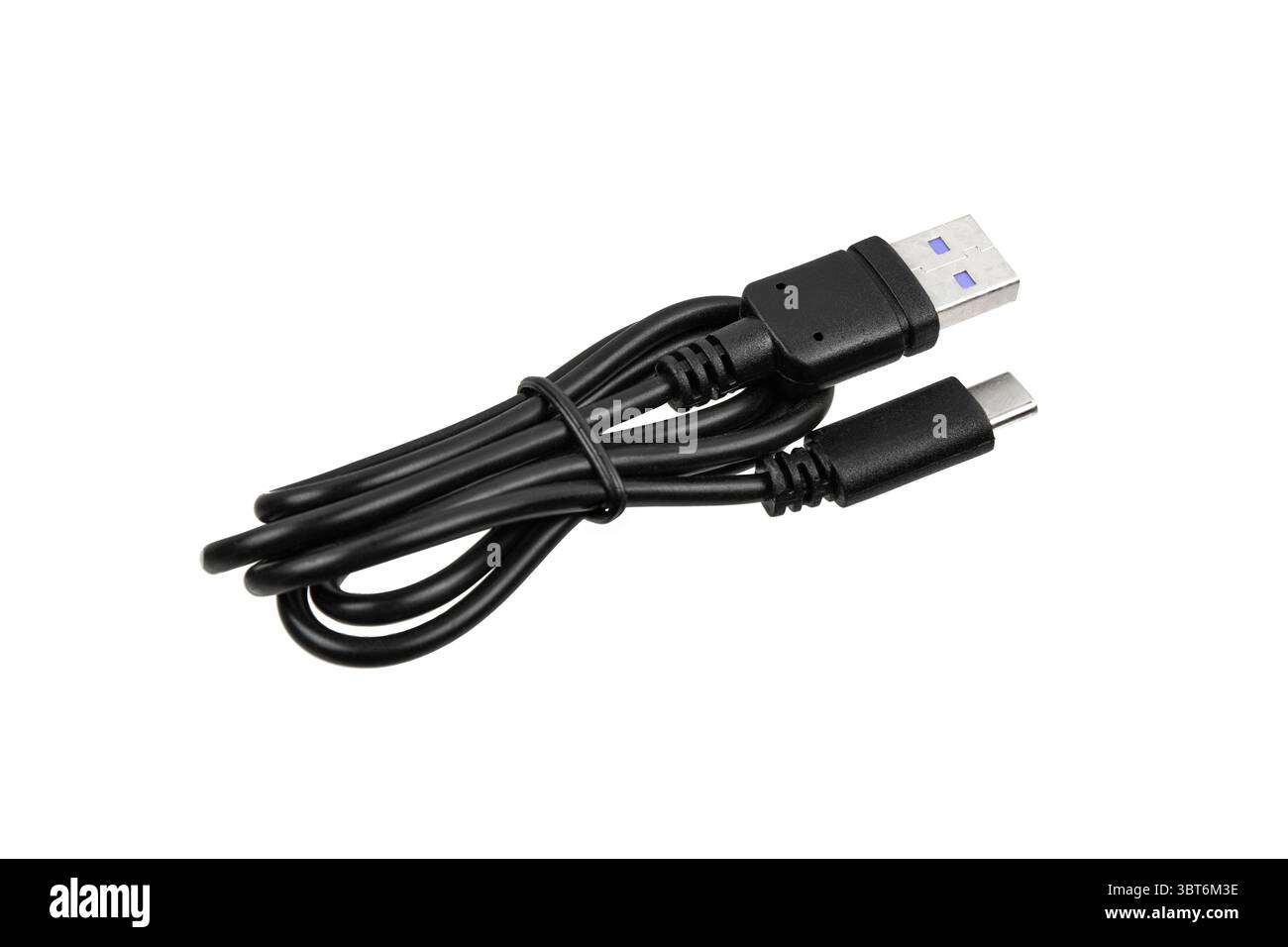 Black USB-A to USB-C charging cable coiled and ready for use. Stock Photo