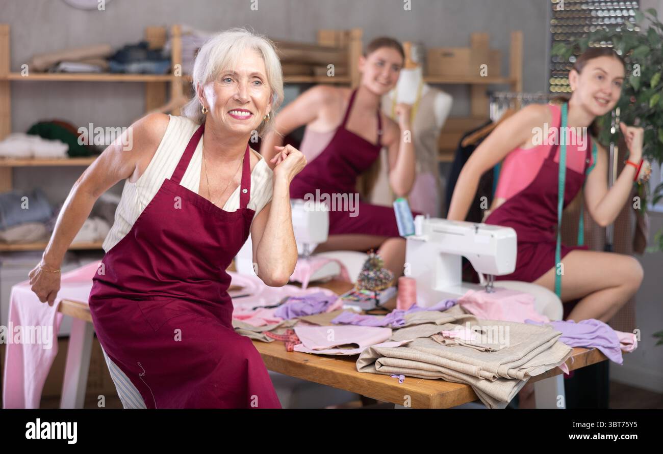 team of dressmakers doing a warm-up in the workshop Stock Photo
