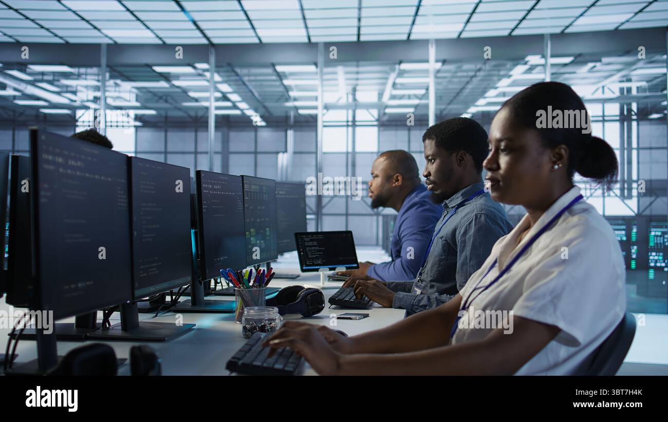 Computer scientists in data center implementing AI predictive maintenance systems. Server farm employees using artificial intelligence to identify hardware failures impacting operations, camera A Stock Photo