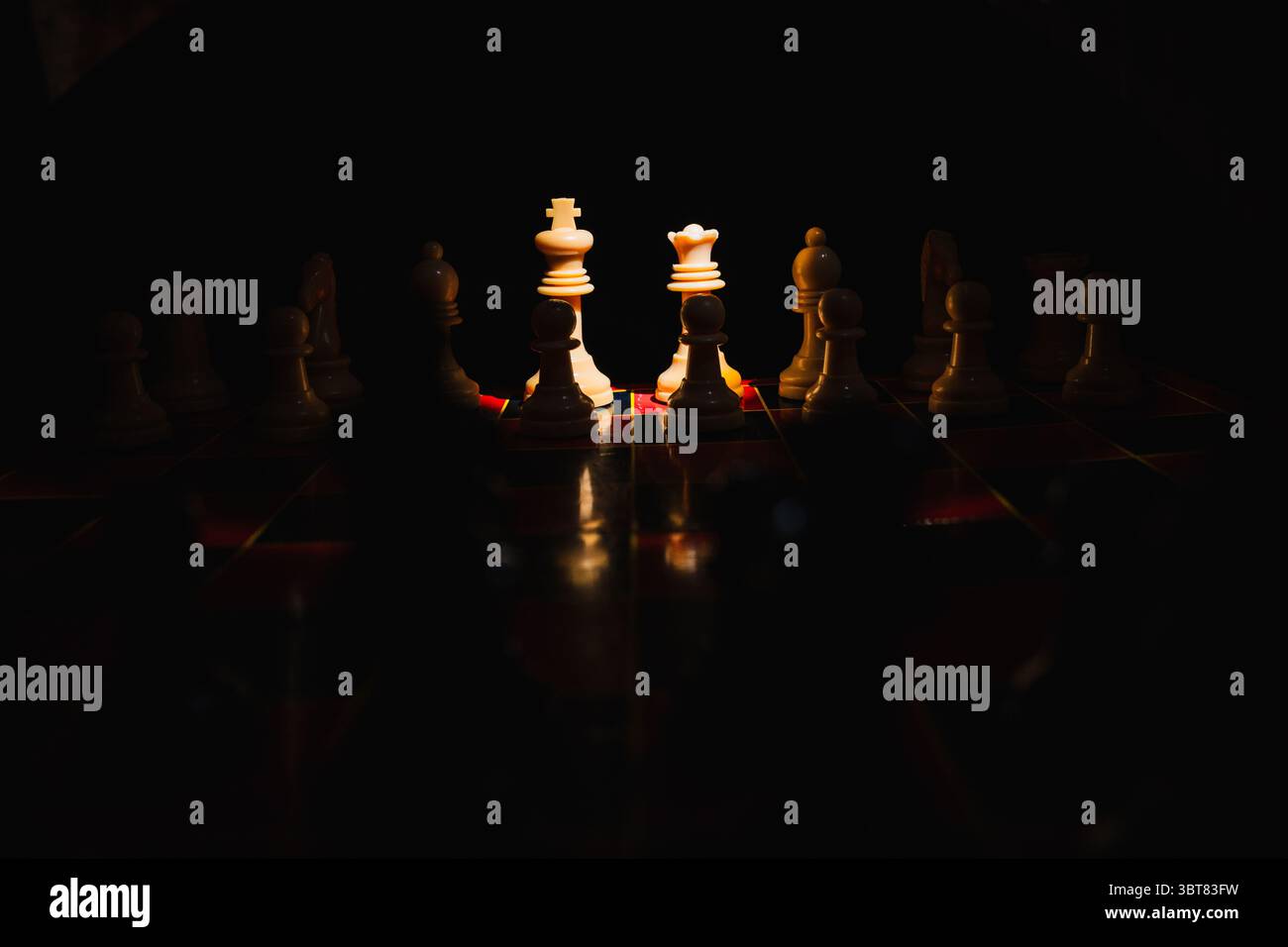Chess pieces on a red and black board with black background Stock Photo ...