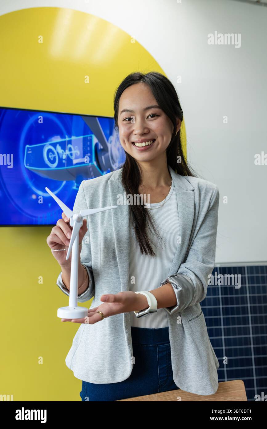 Asian Chinese woman holding scale turbine model behind table in lab ...