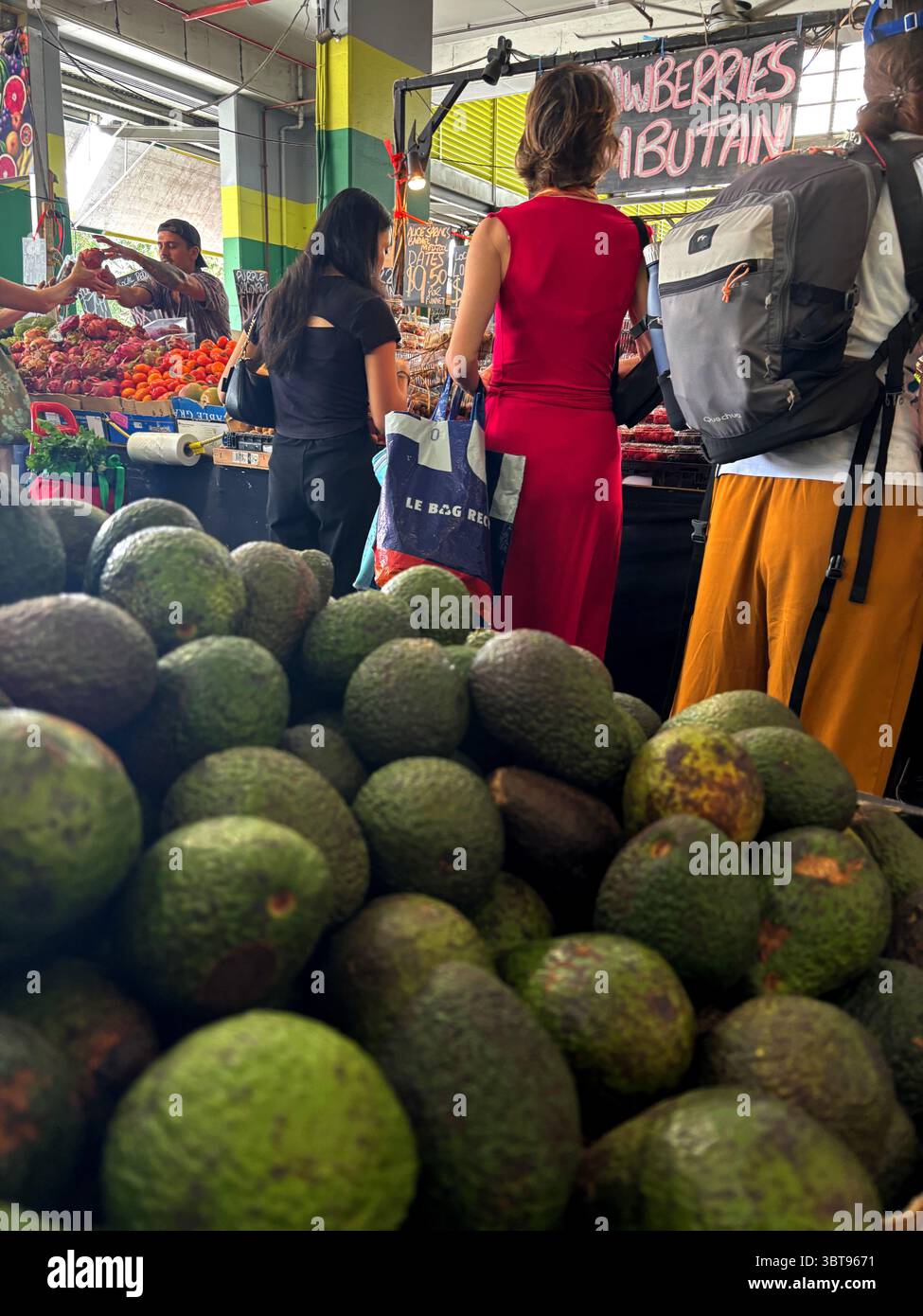 People shopping amongst piles of avocados and other tropical fruits, Rustys Markets, Cairns, Queensland, Australia. No MR or PR Stock Photo