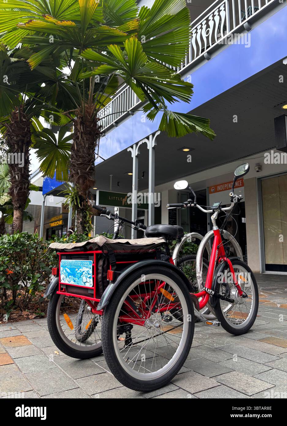 Red tricycle with 'Great Barrier Reef' branding parked outside Little Drifter hostel, Shields Street, Cairns, Queensland, Australia. No PR - Smartphone Captured Stock Image Red tricycle with 'Great Barrier Reef' branding parked outside Little Drifter hostel, Shields Street, Cairns, Queensland, Australia. No PR - Smartphone Captured Stock Image
