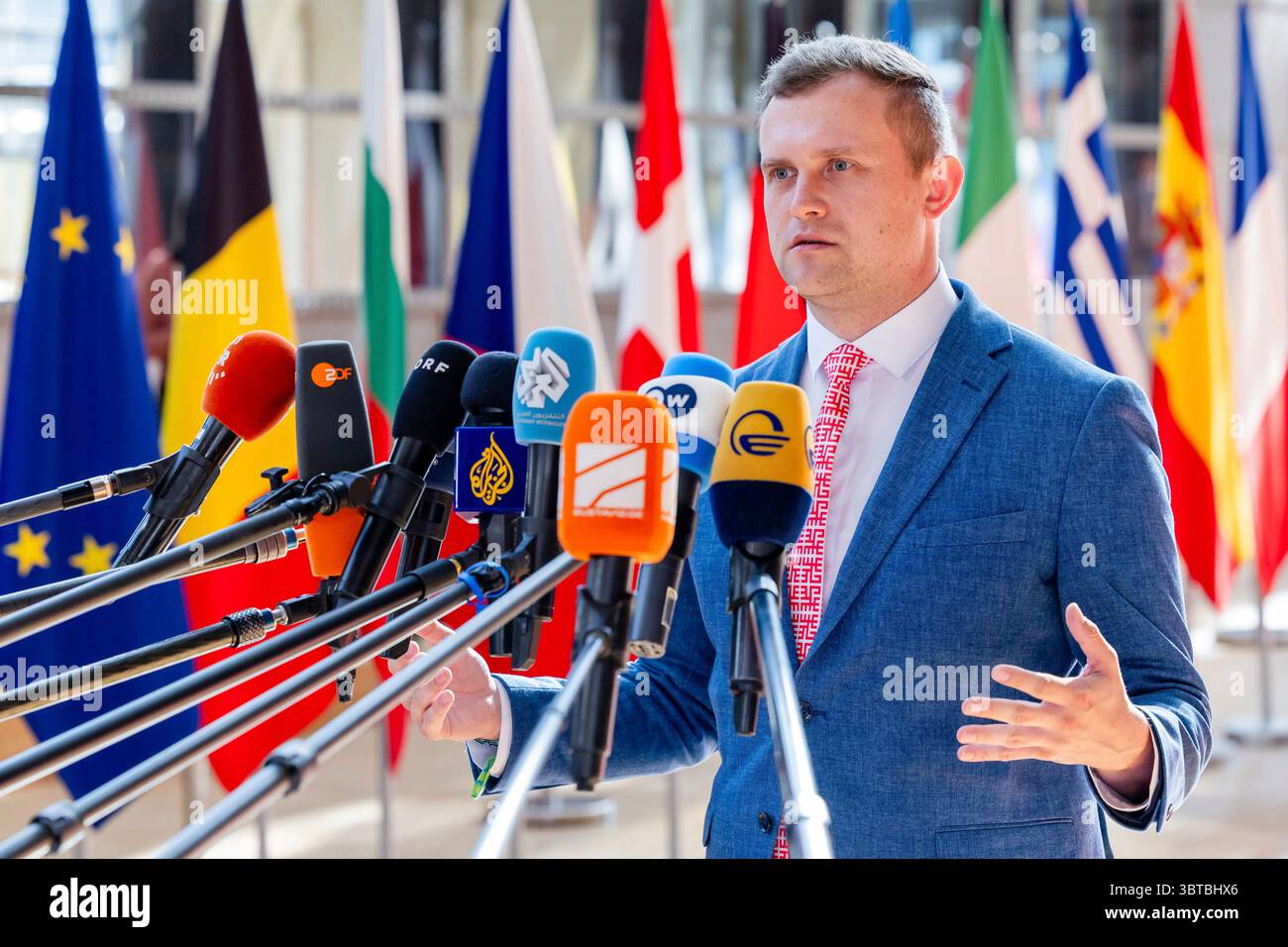 Why is Latvia calling for a 0.25% GDP benchmark?