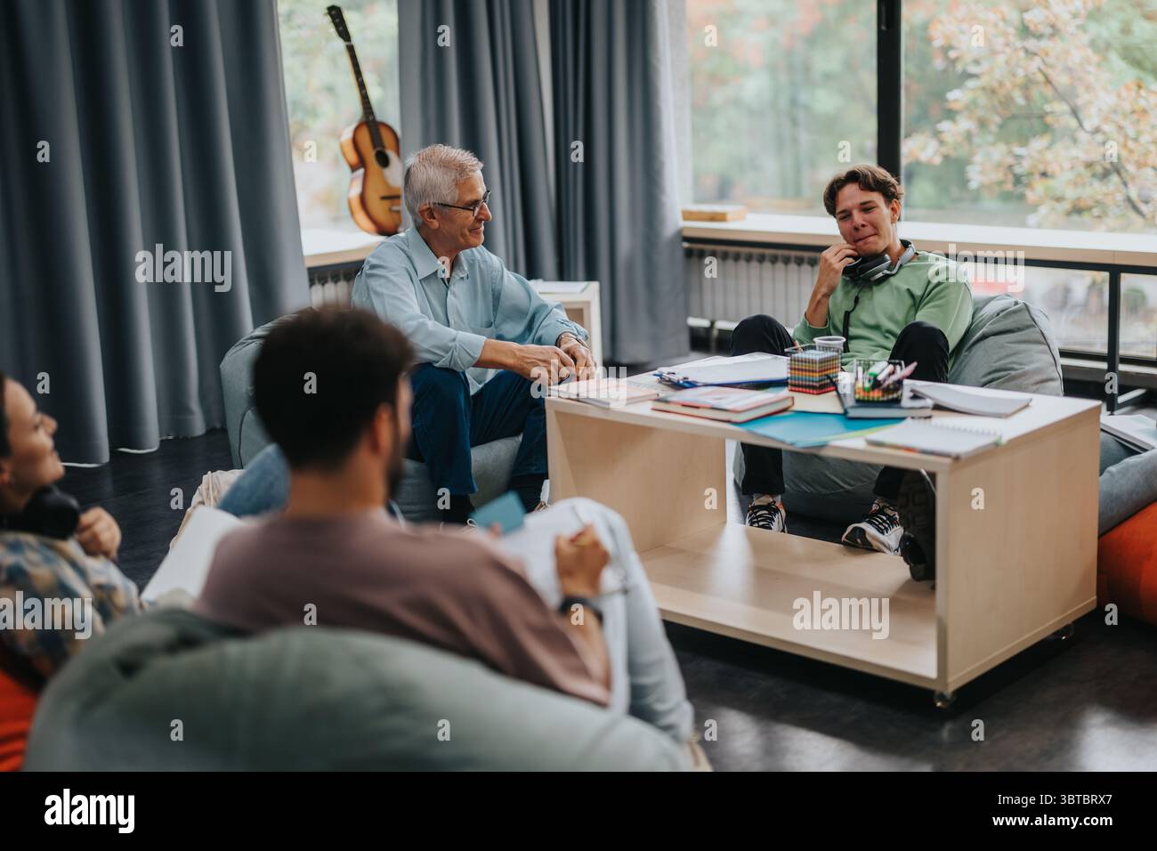 Professor engaging with students in a comfortable study environment Stock Photo