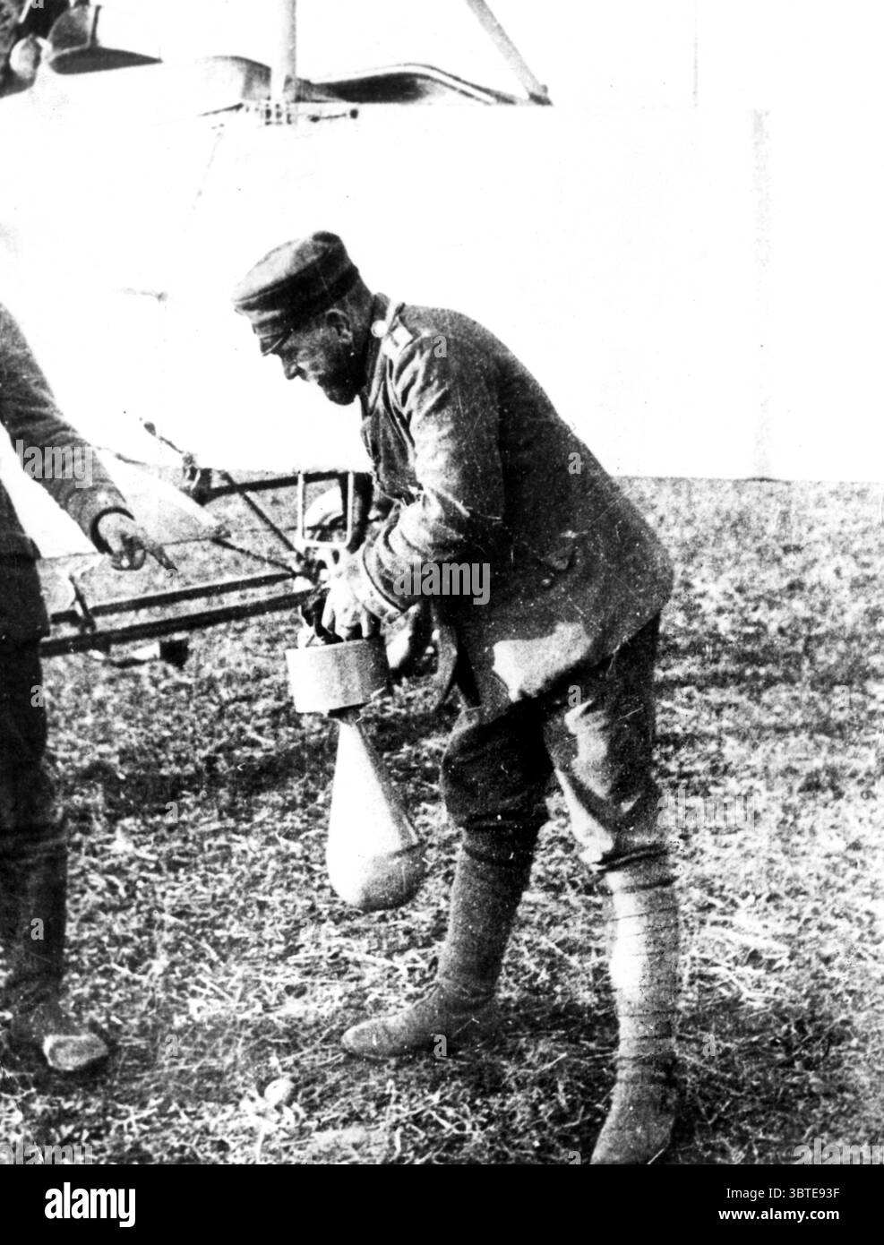 World War One - Aviation A German troop fixes a bomb to the undercarriage of a German plane.  1915 Stock Photo