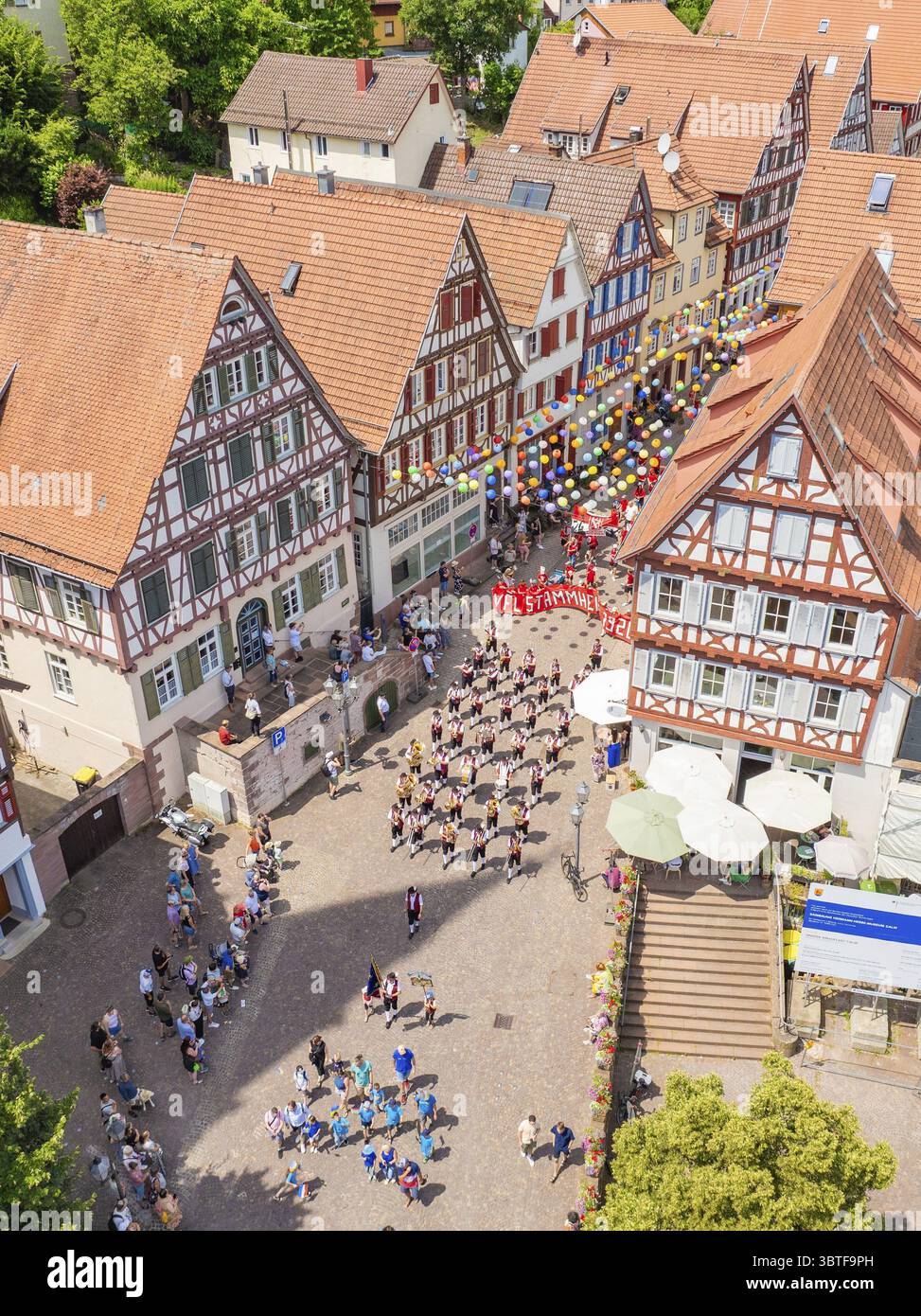 A large crowd gathers in front of half-timbered buildings during a ...