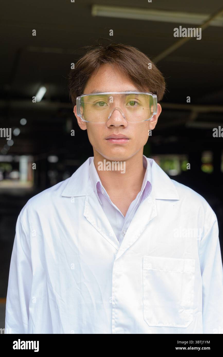 Young Asian scientist student researcher wearing lab coat Stock Photo