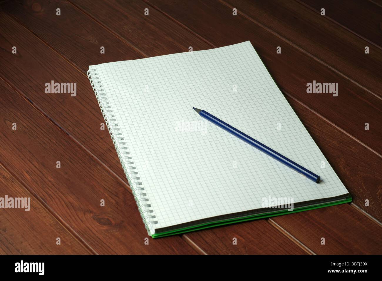 A simple notebook lies open on a wooden table, inviting new ideas and thoughts. Stock Photo