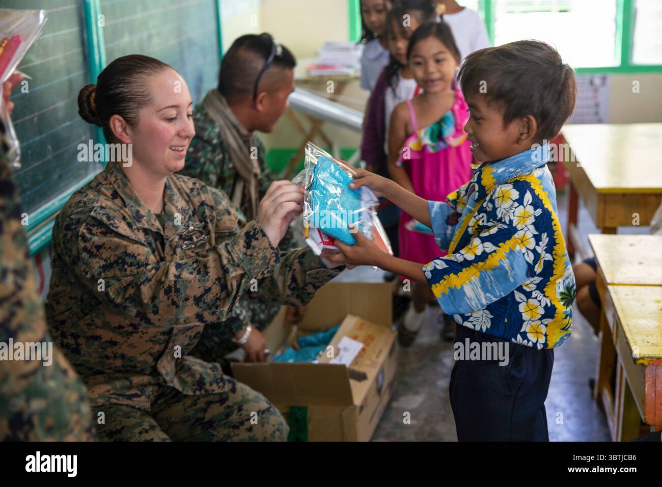 October 16, 2019 - San Antonio, Philippines - U.S. Navy Petty Officer 2nd Class Bethany L. Tracy passes out gifts to local grade school students with Philippine Navy sailors during KAMANDAG 3