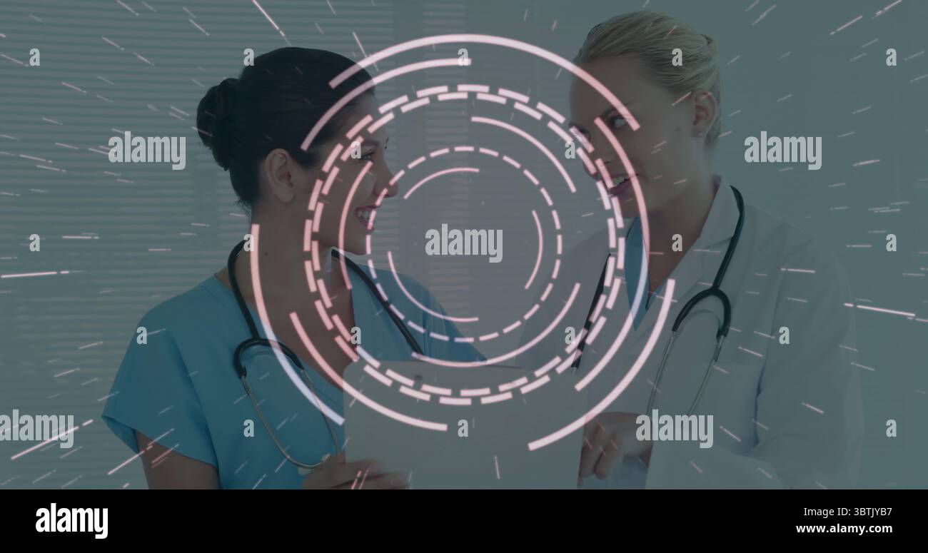 Nurse in scrubs and doctor in coat reviewing chart in clinic, with ...
