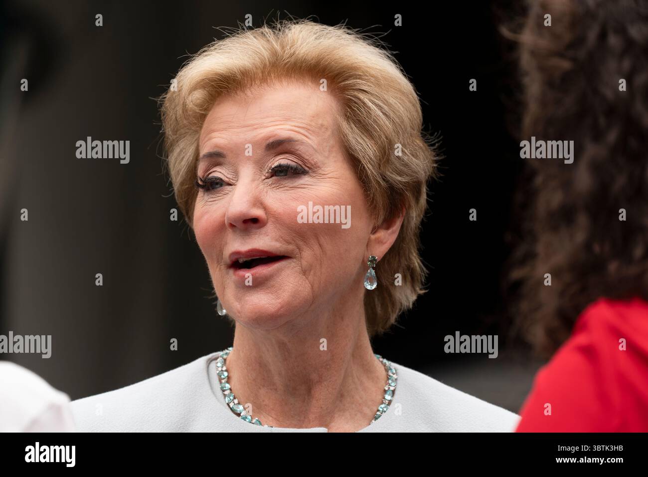 Education Secretary Linda McMahon, talks to her staff as they wait on