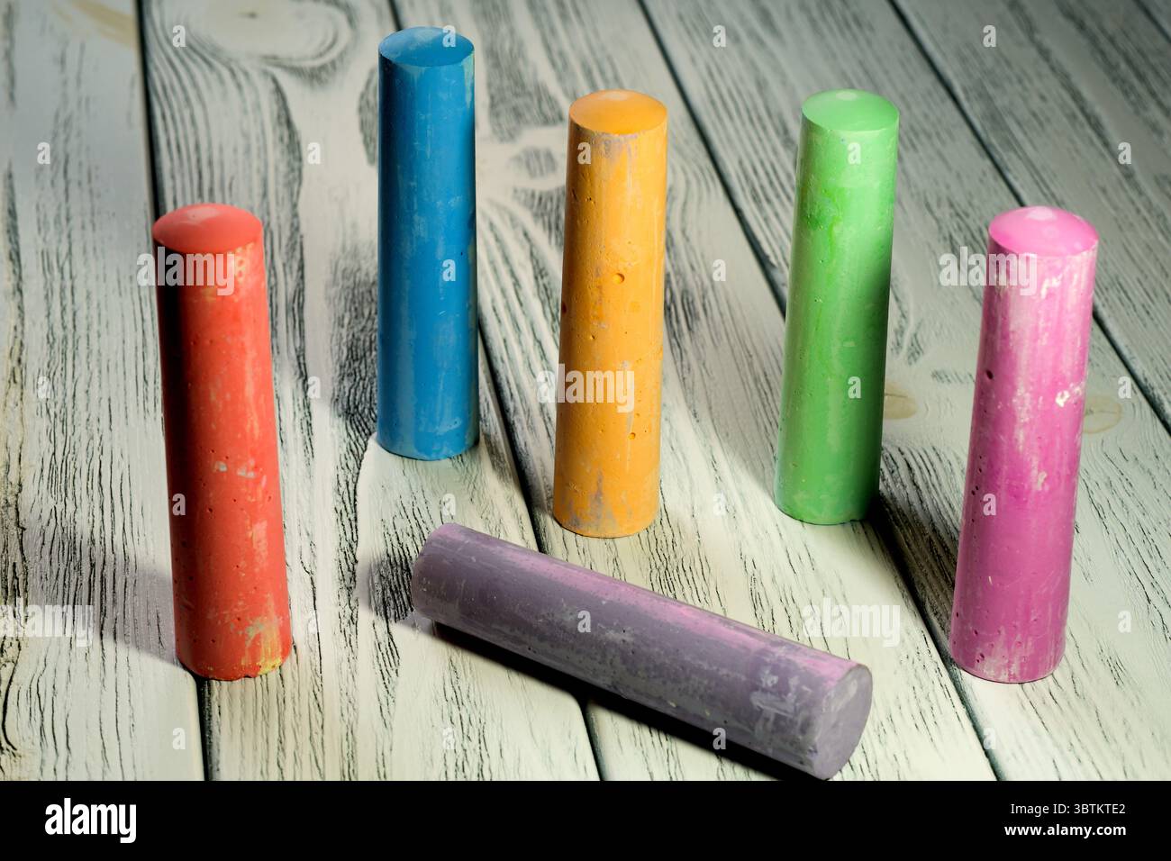 Colored crayons for drawing on a white wooden table in twilight light stationery educational background Stock Photo