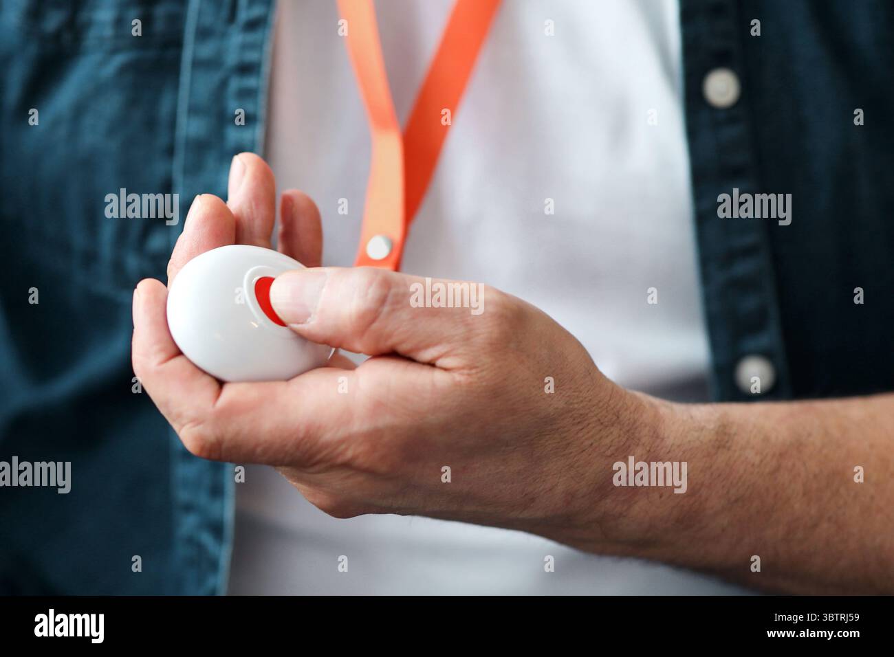 Unrecognizable old man pushing red button for emergency Stock Photo