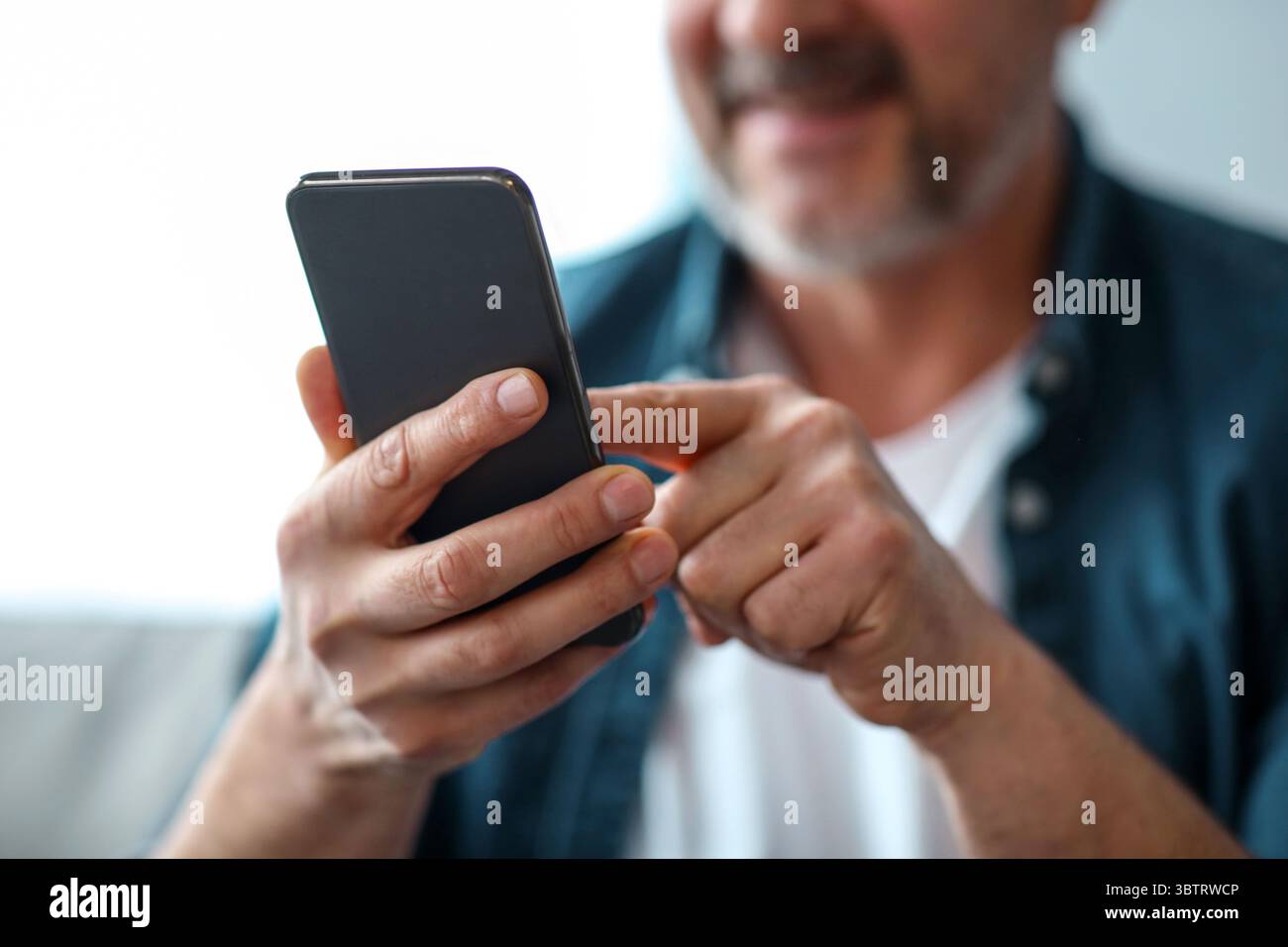 Unrecognizable matured man using modern mobile phone Stock Photo