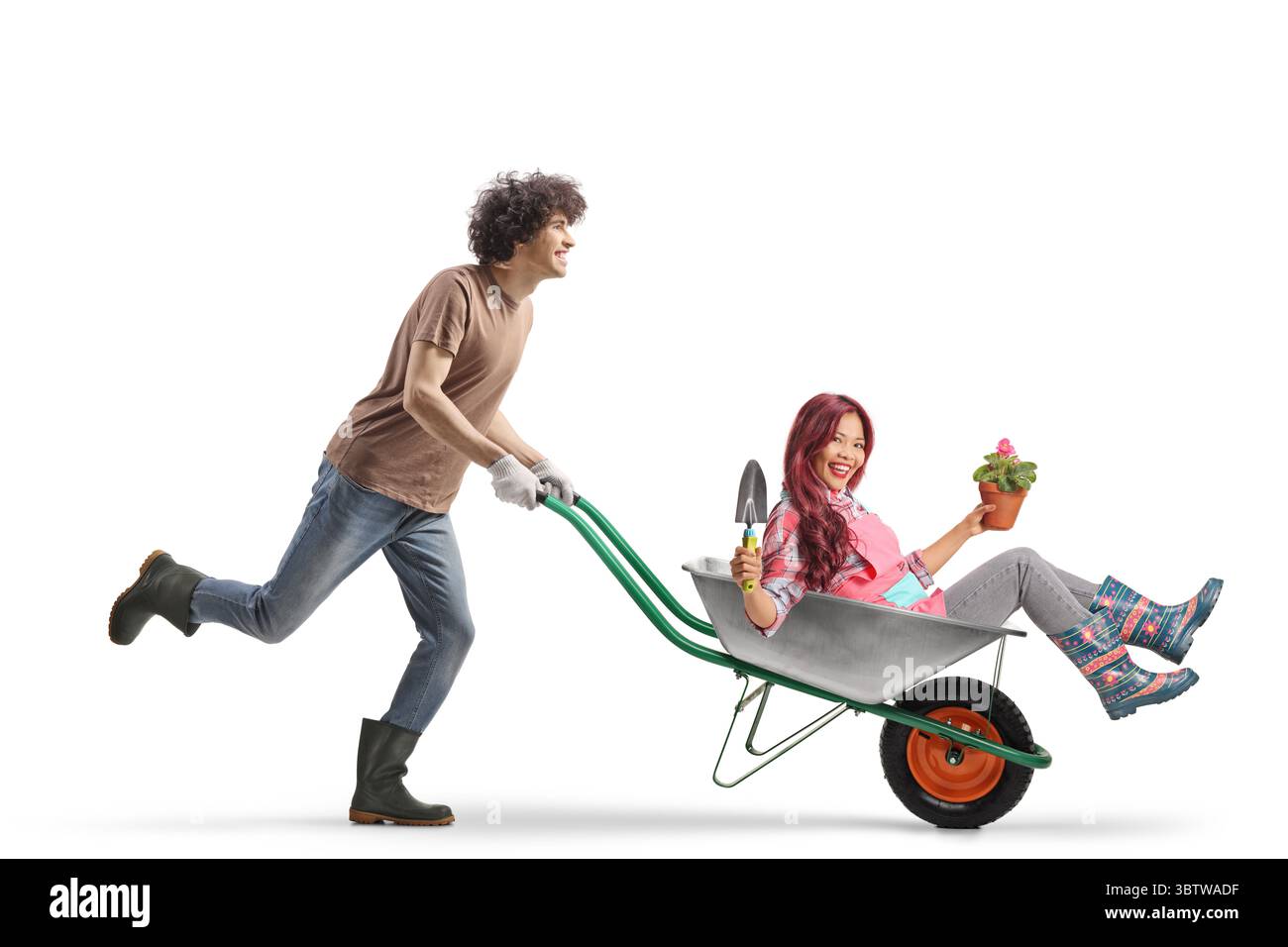 Young man and woman with a wheelbarrow having fun while gardening ...