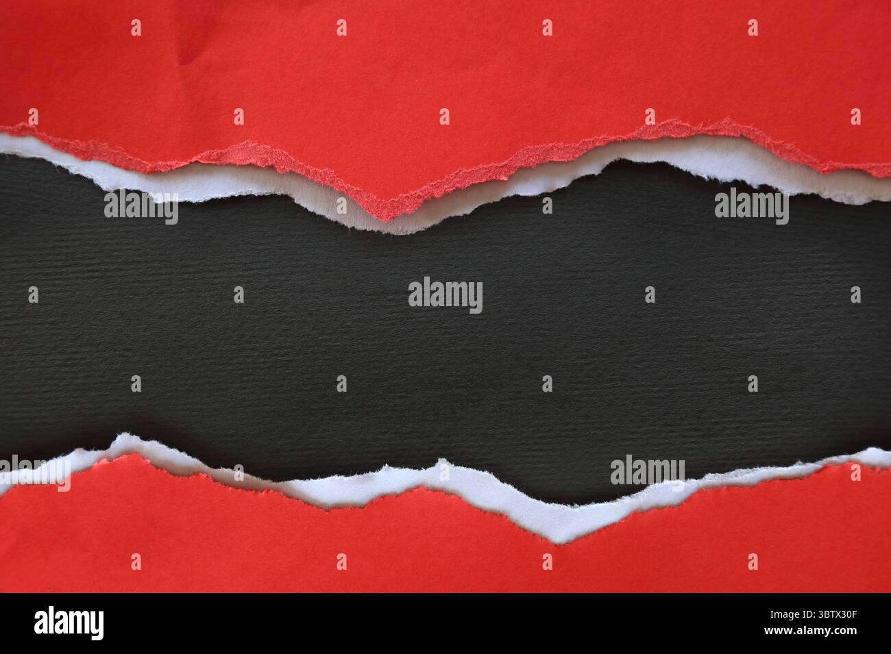 Ripped red paper on black background Stock Photo