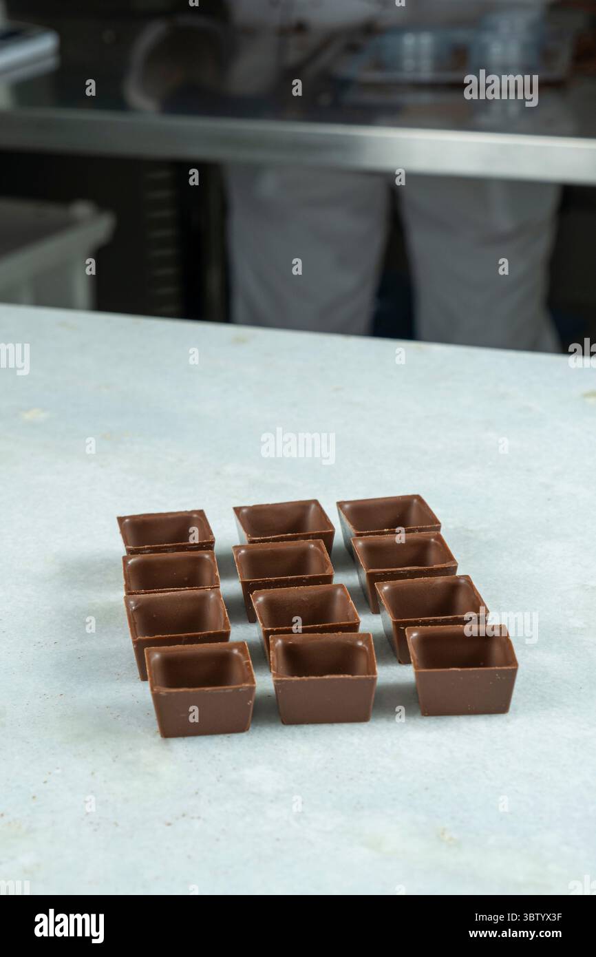 Square-shaped milk chocolate shells ready to be filled side view Stock ...