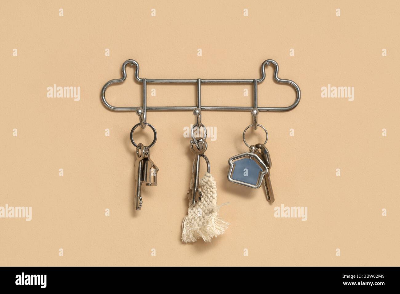 Rack with keys from house on beige wall Stock Photo
