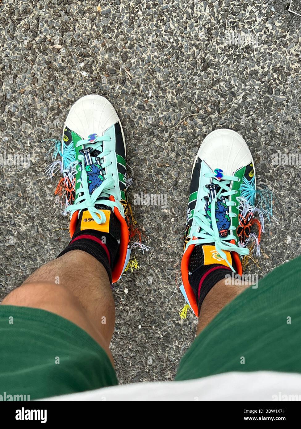 Top-down, close-up of Adidas Superstar Sean Wotherspoon SuperEarth sneakers. Vibrant embroidery details on eco-conscious footwear, Singapore. Vertical - Smartphone Captured Stock Image