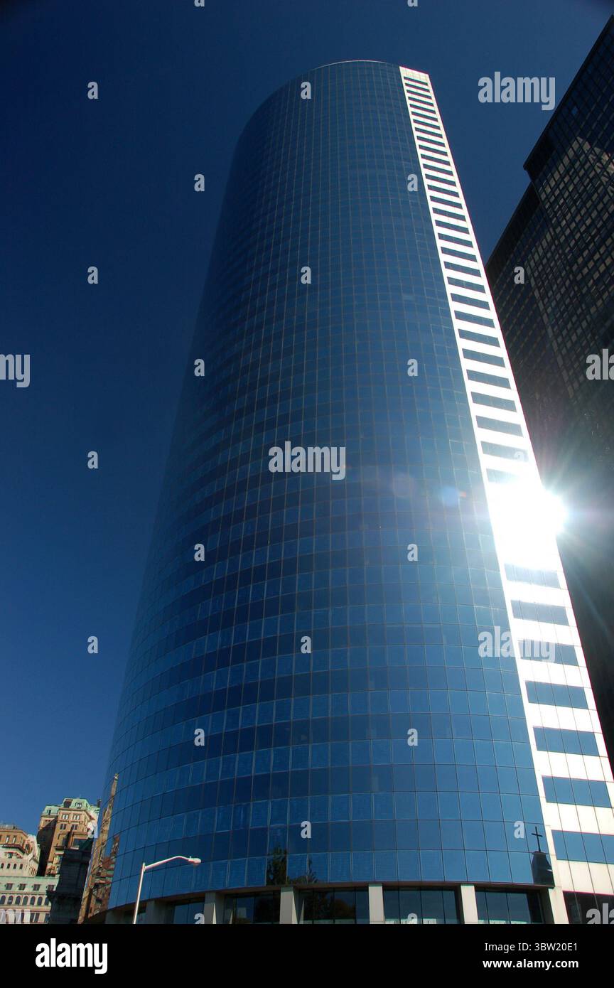 Modern glass skyscraper reflecting sunlight under a clear blue sky in ...