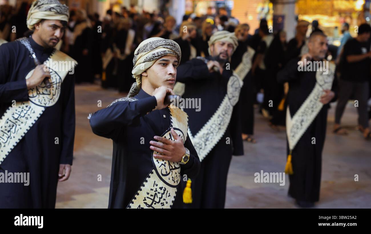 Men in black clothing perform a cultural ritual in An Najaf, Iraq ...