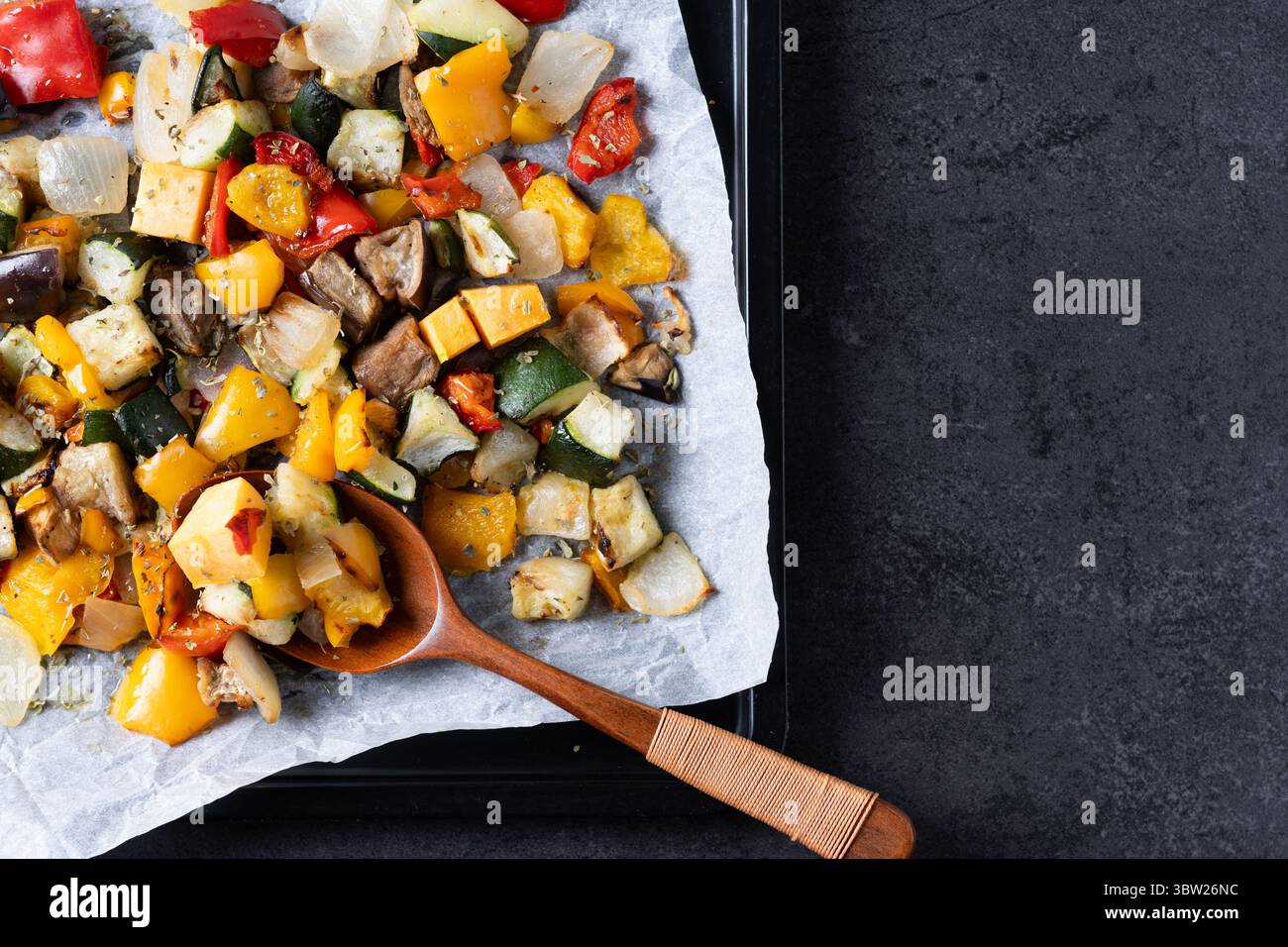Roasted vegetabes on black slate background Stock Photo