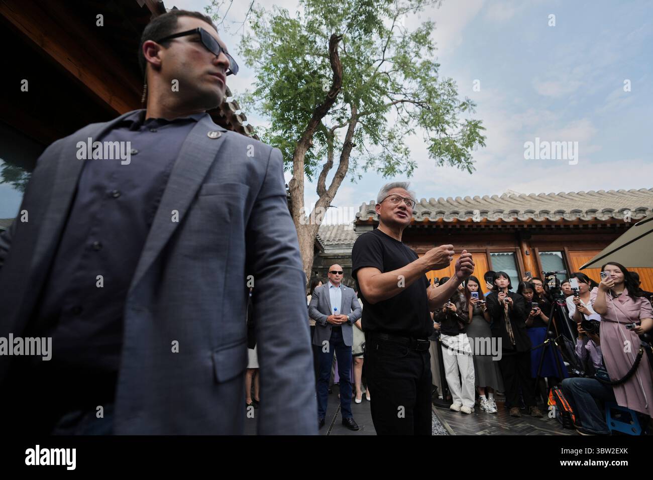 Bodyguards stand watch as CEO of Nvidia Jensen Huang speaks to ...