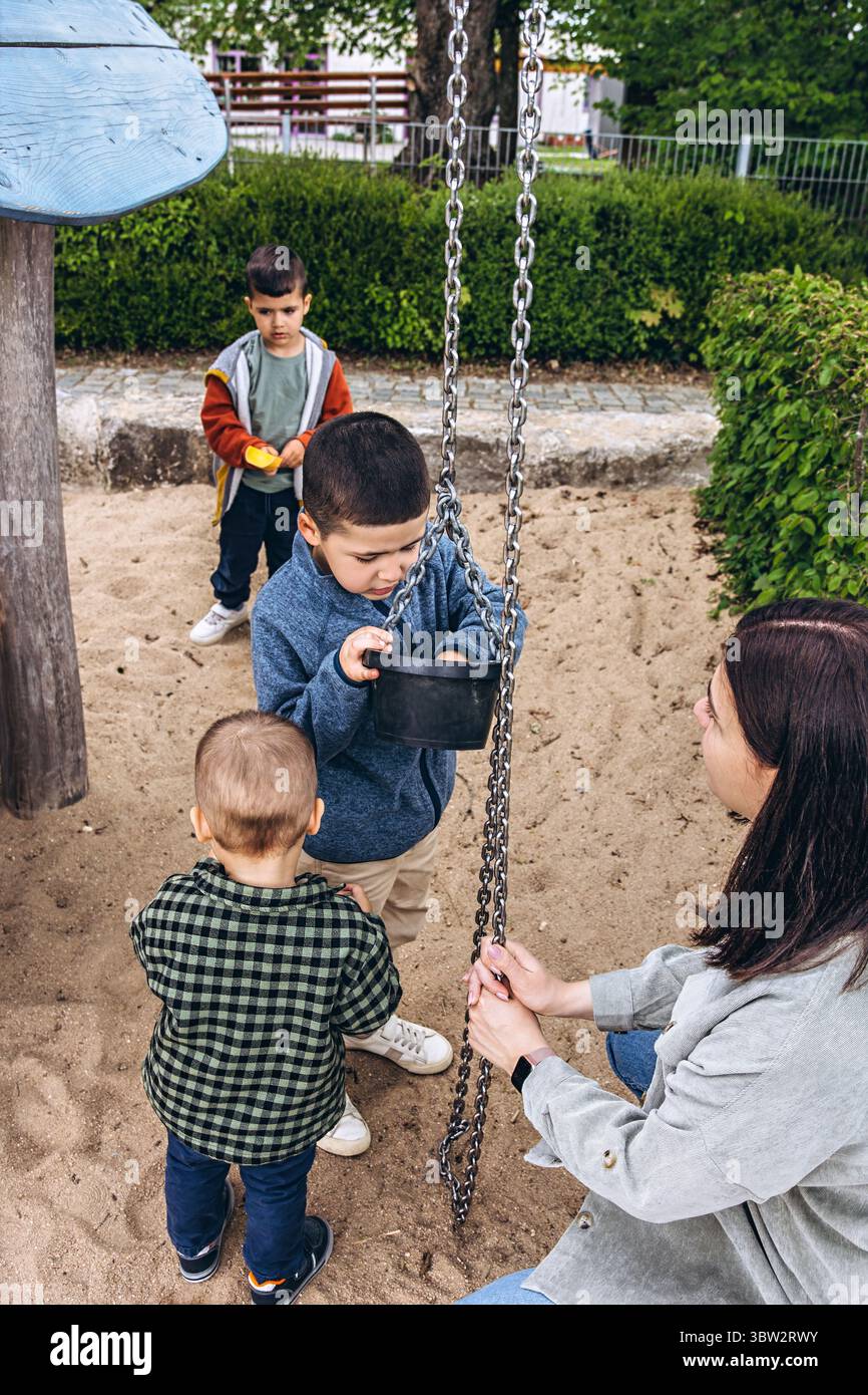 Three children playing sandbox hi-res stock photography and images