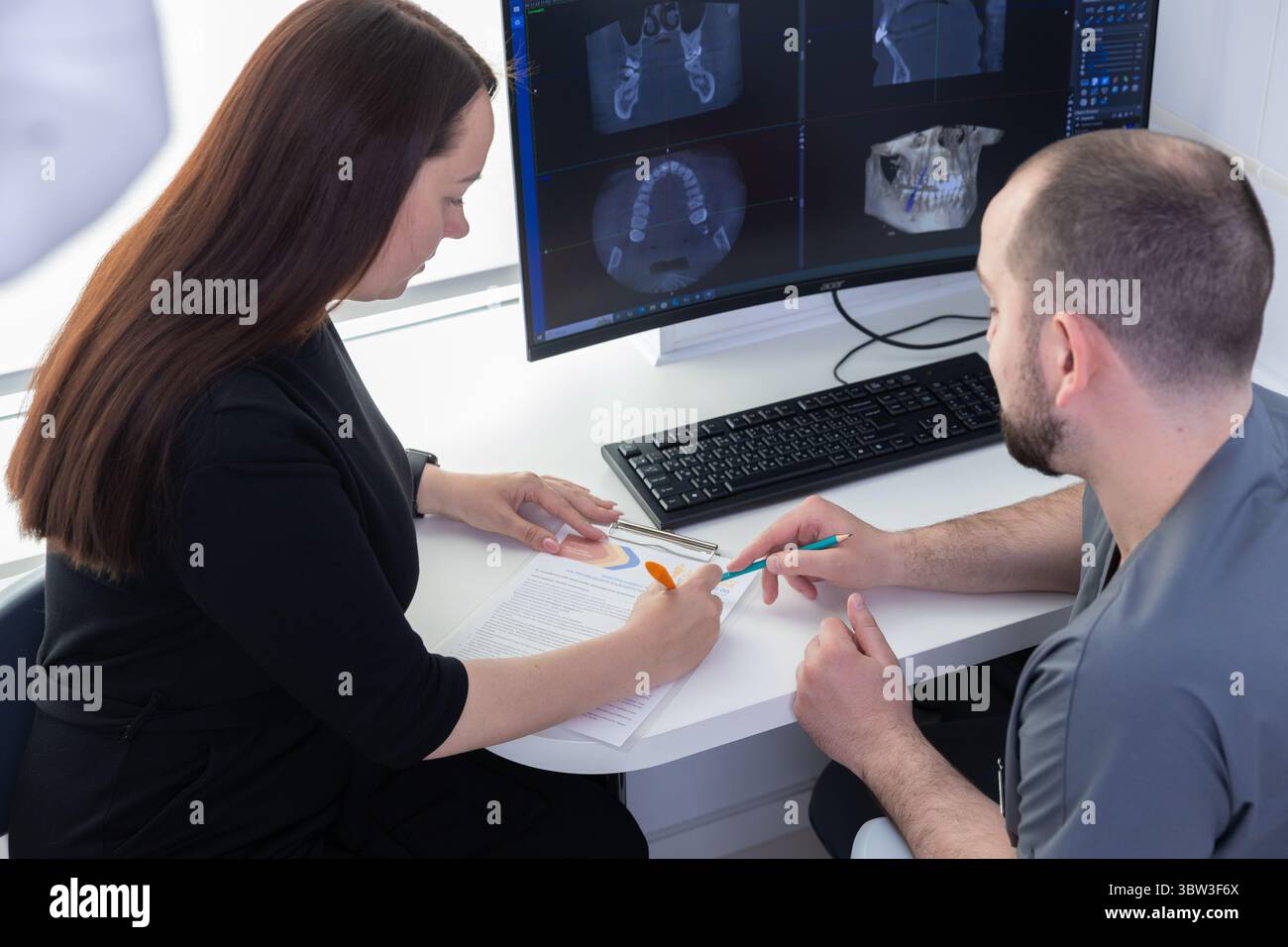 Patient Consultation in a Modern Dental Office: A Professional Discussion About Dental Imaging and Treatment Options for Optimal Oral Health and Care Stock Photo