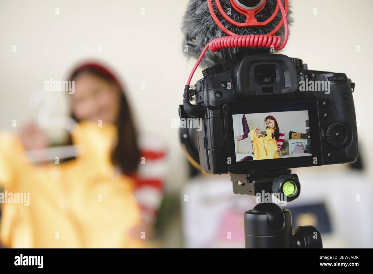 Professional DSLR digital camera film video live with vlogger blogger interview background. Woman coaching trading and review clothing product. Busine Stock Photo