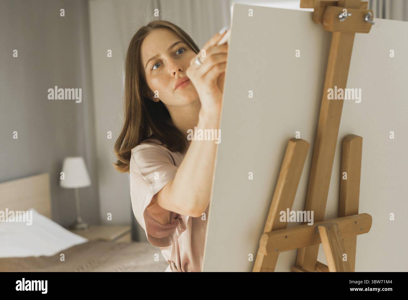 Ziemlich talentierte Frau Maler Malerei Nahaufnahme auf Staffel machen bunte Skizzen schaffen wunderbare Kunst. Schoene Kuenstlerin Malerei mit Pastel Stock Photo