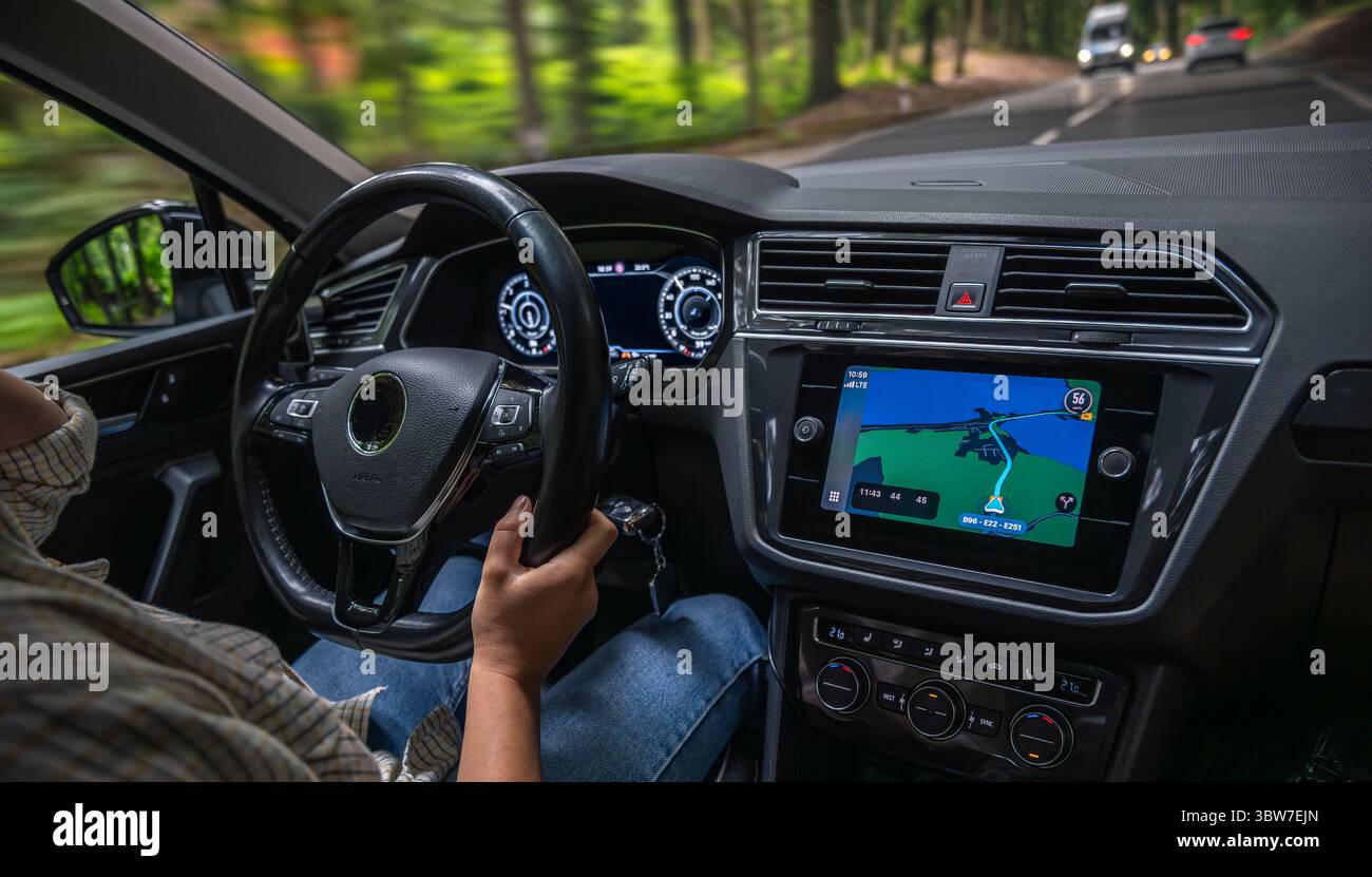 Female driver steering car. Driving forest road. Navigation display ...