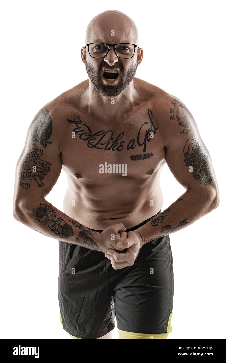 Handsome bald, bearded, tattooed man in glasses, black shorts is posing ...